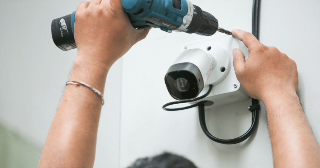 man installing a security camera