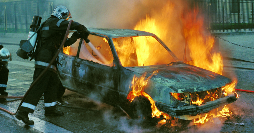 using a fire extinguisher on a burning car