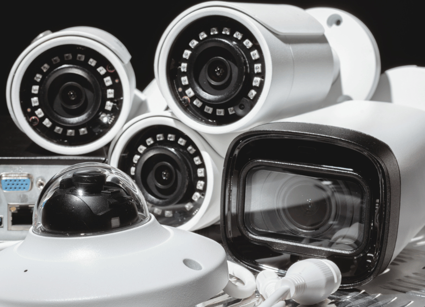 A group of security cameras, including bullet and dome styles, is displayed together, showcasing various surveillance equipment used for monitoring and protection.